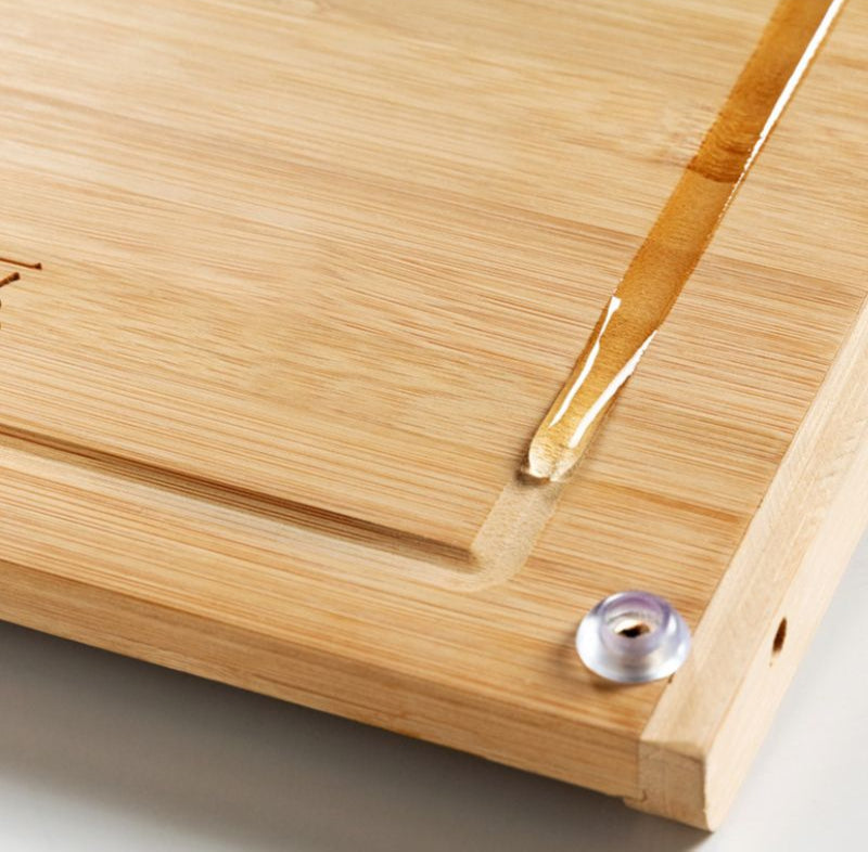 Holzschneidebrett mit Rillen und praktischer Messerschlitzhalterung.