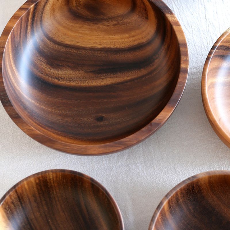 Obenansicht runder Holzschalen mit markanter Maserung auf einem Tisch.