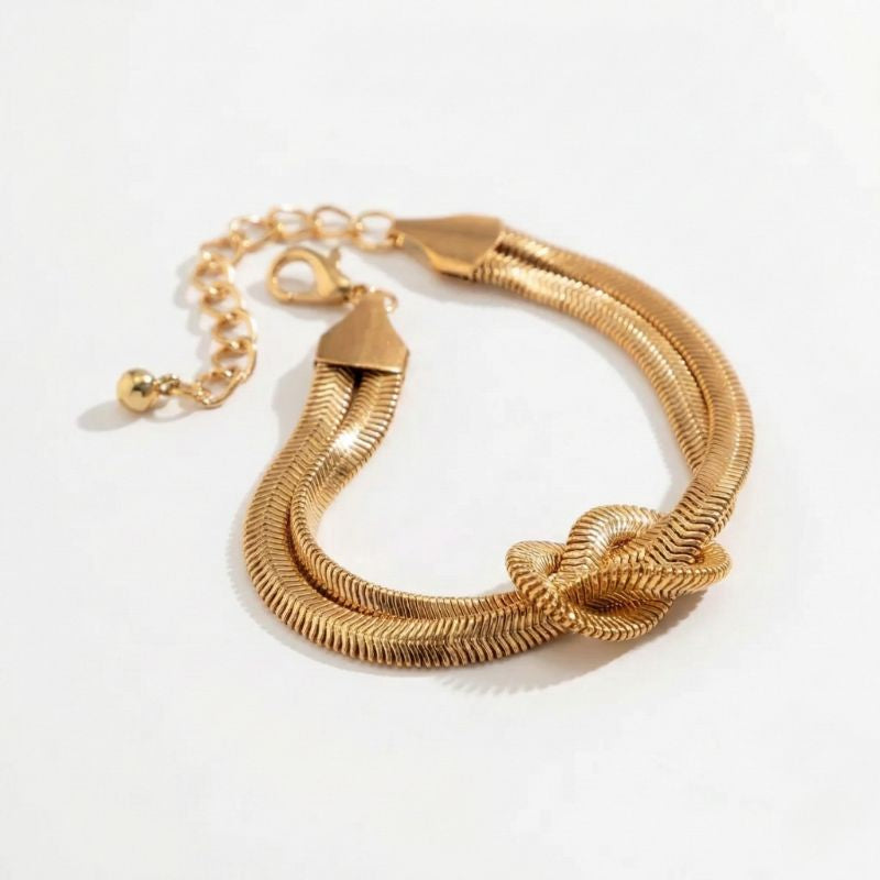 Damenarmband mit geflochtener Metallstruktur und dekorativem Knoten, in Gold- oder Silberoptik am Handgelenk sowie in Detailansicht dargestellt