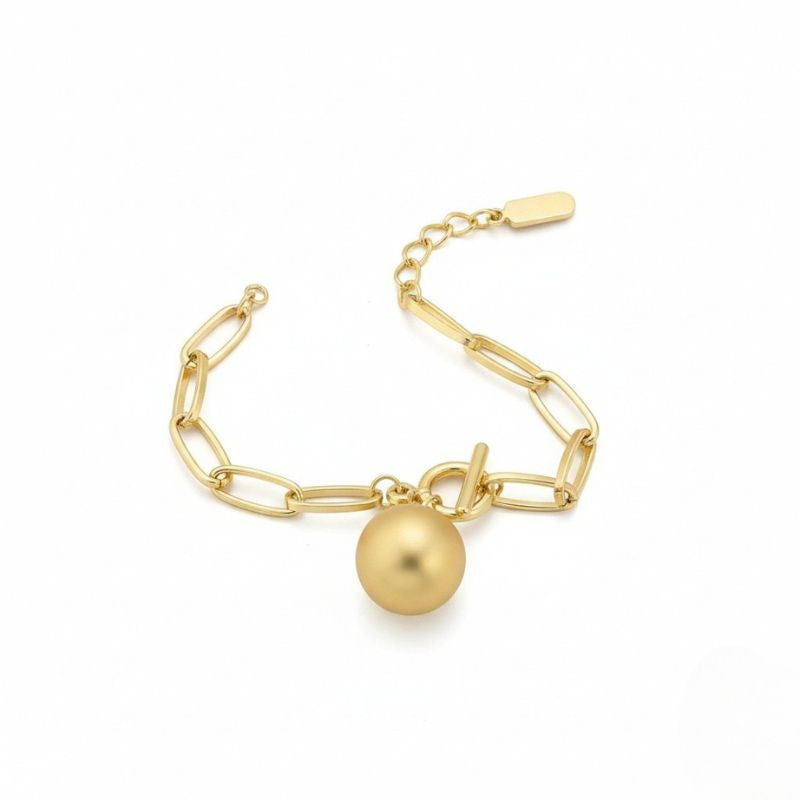 Goldfarbenes Damen-Gliederarmband mit Kugelanhänger, getragen am Handgelenk und in Nahaufnahme dargestellt