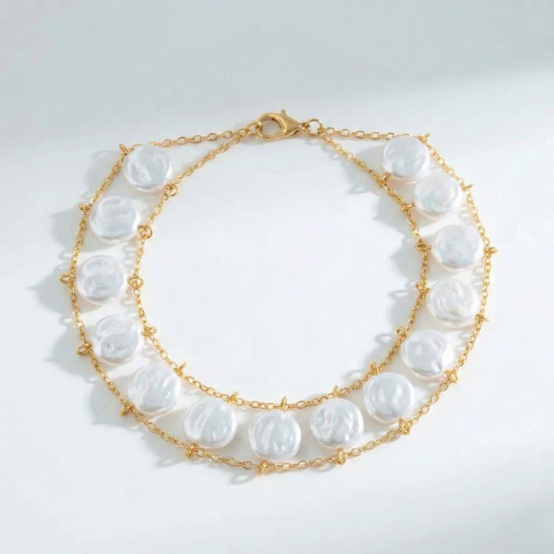 Damen-Perlenarmband mit flachen Perlen und goldfarbener Doppelkettenstruktur, getragen am Handgelenk und in Detailansicht dargestellt